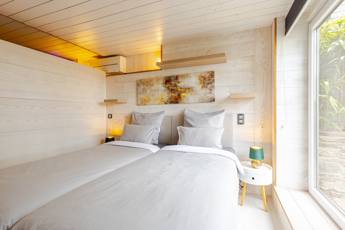 Chambre 2 du Gîte de Lierneux en bois clair avec grand lit double et lumière naturelle