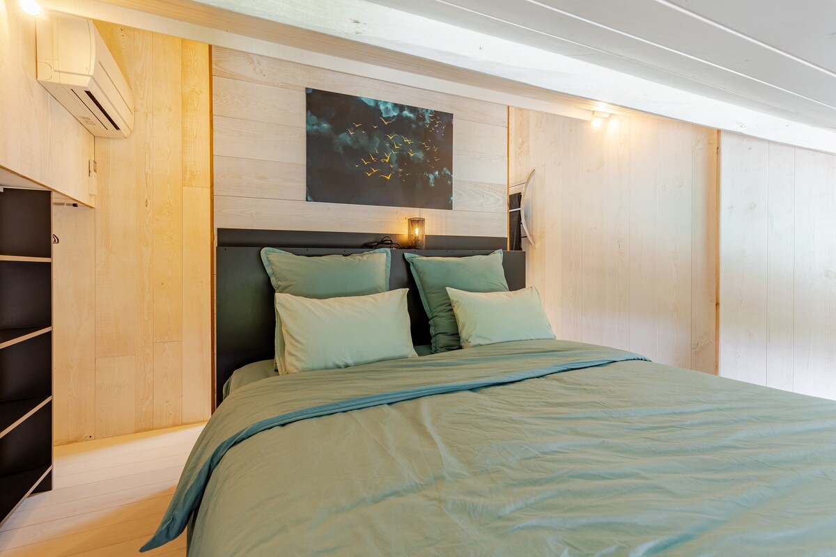 Chambre 1 du Gîte de Lierneux avec grand lit en lin vert et lambris bois