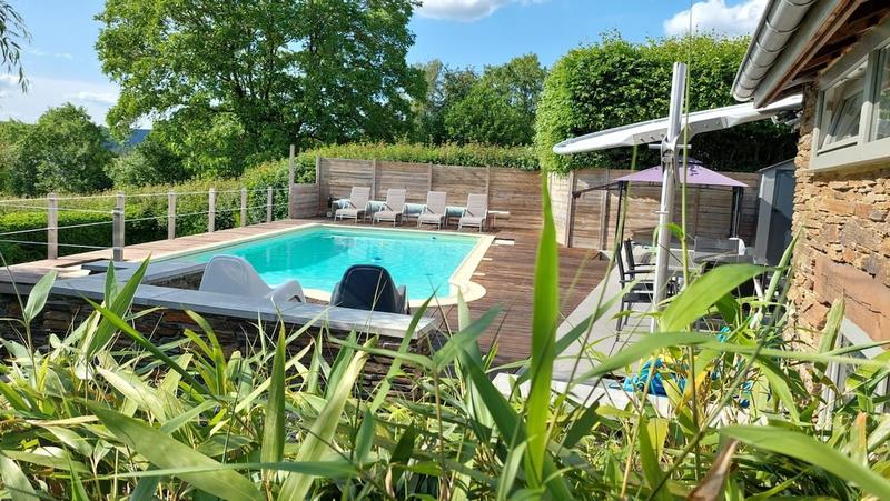 Piscine chauffée vue du jardin en été