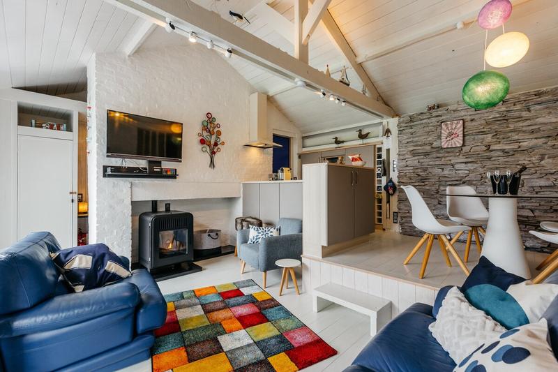 Salon avec poêle et mur en pierre