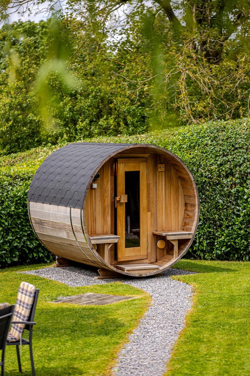 Sauna tonneau dans le jardin en été